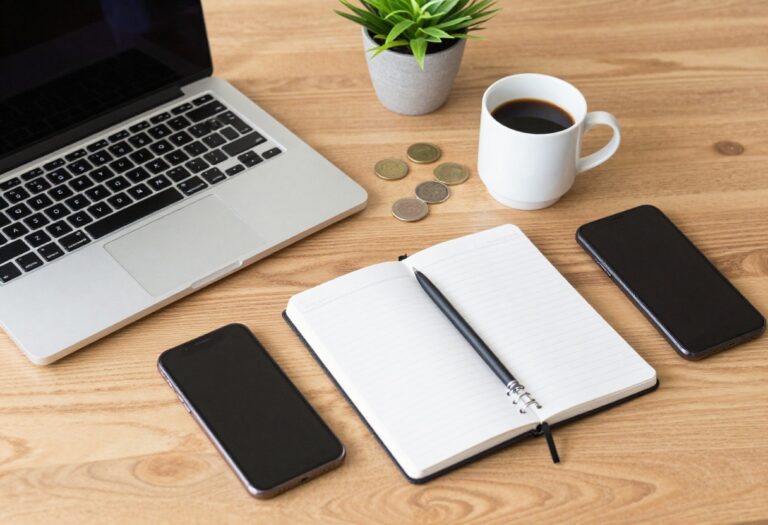 Flat lay of laptop, coffee, notebook, and coins on a desk, symbolizing side hustle ideas for busy schedules.